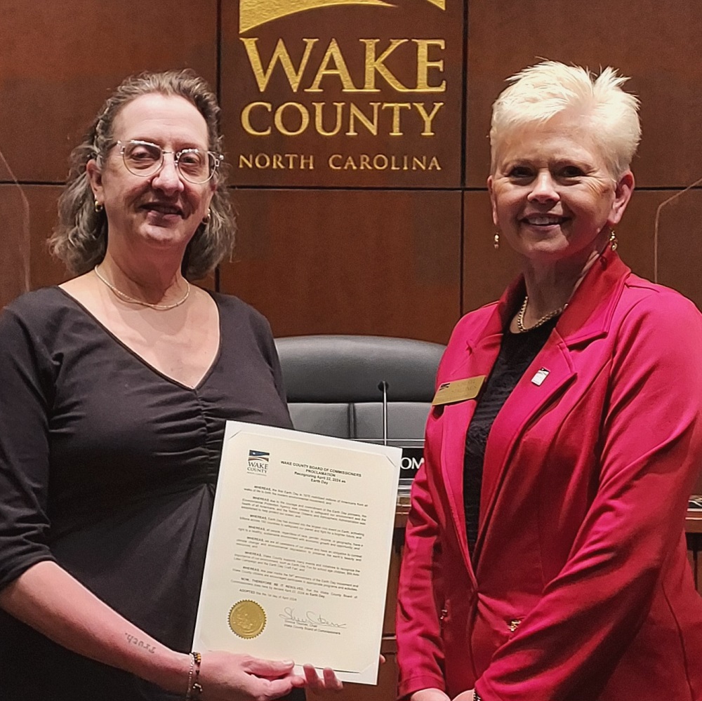 Margaret Lillard of the NC Sierra Club accepts an Earth Day 2024 proclamation from Wake County Commissioner Cheryl Stallings