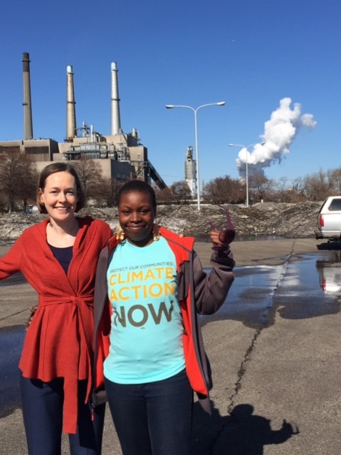 Mary Anne Hitt stands next to a resident affected by the coal plant in the background
