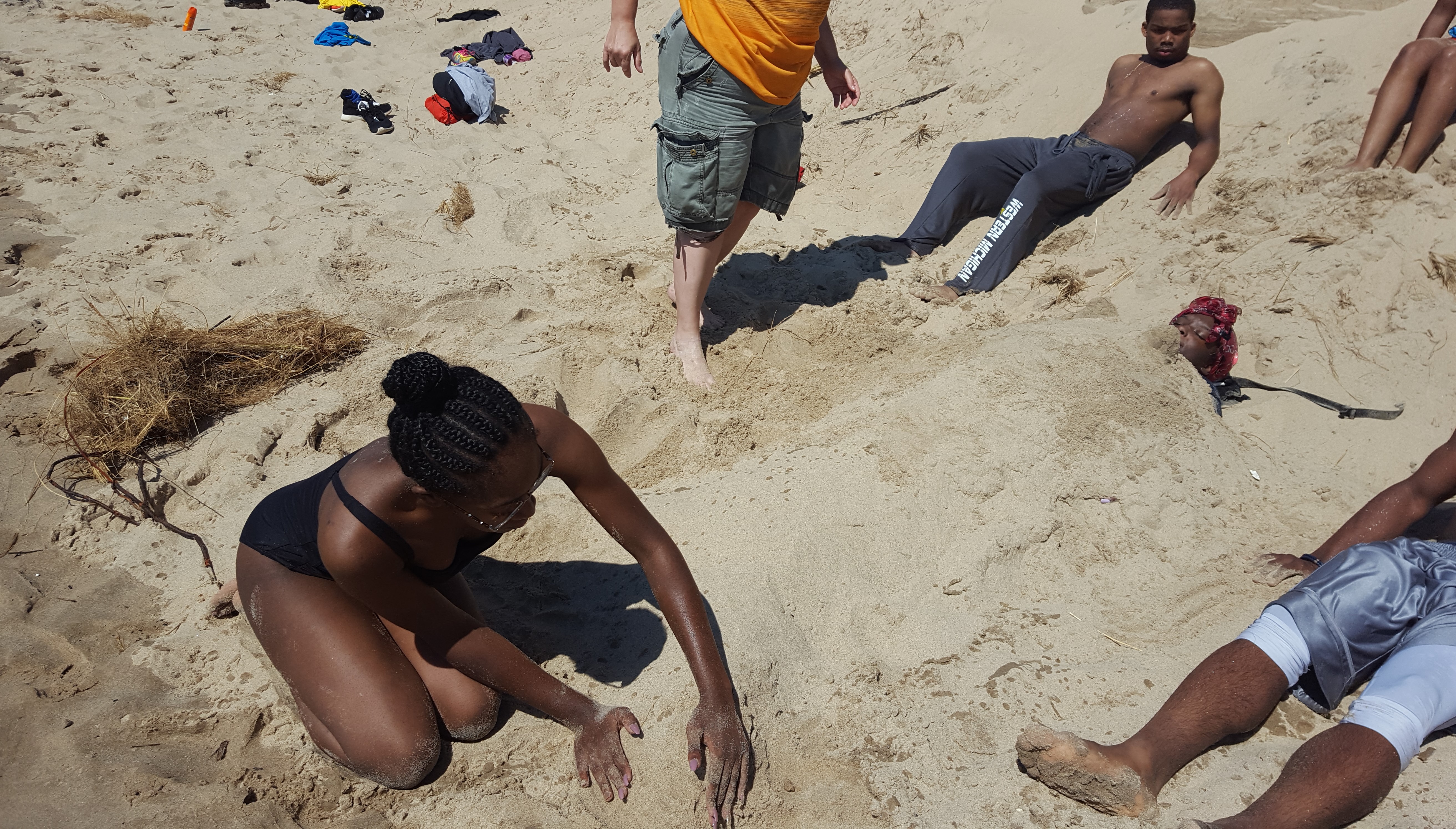 Asia Jones buries her friends in the sand along Lake Michigan.