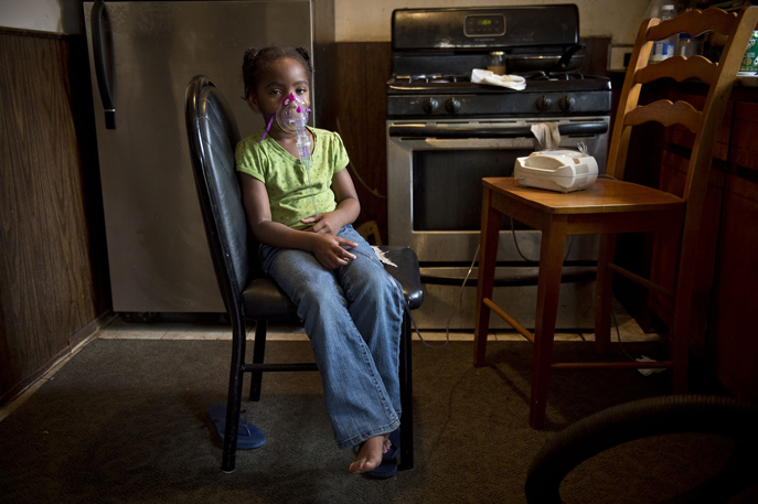 Five-year-old La 'Miyah Hildreth wears a nebulizer in the kitchen of her grandmother Siobhan Washington. First published in the November/December 2012 Issue of Sierra, the magazine of the Sierra Club.