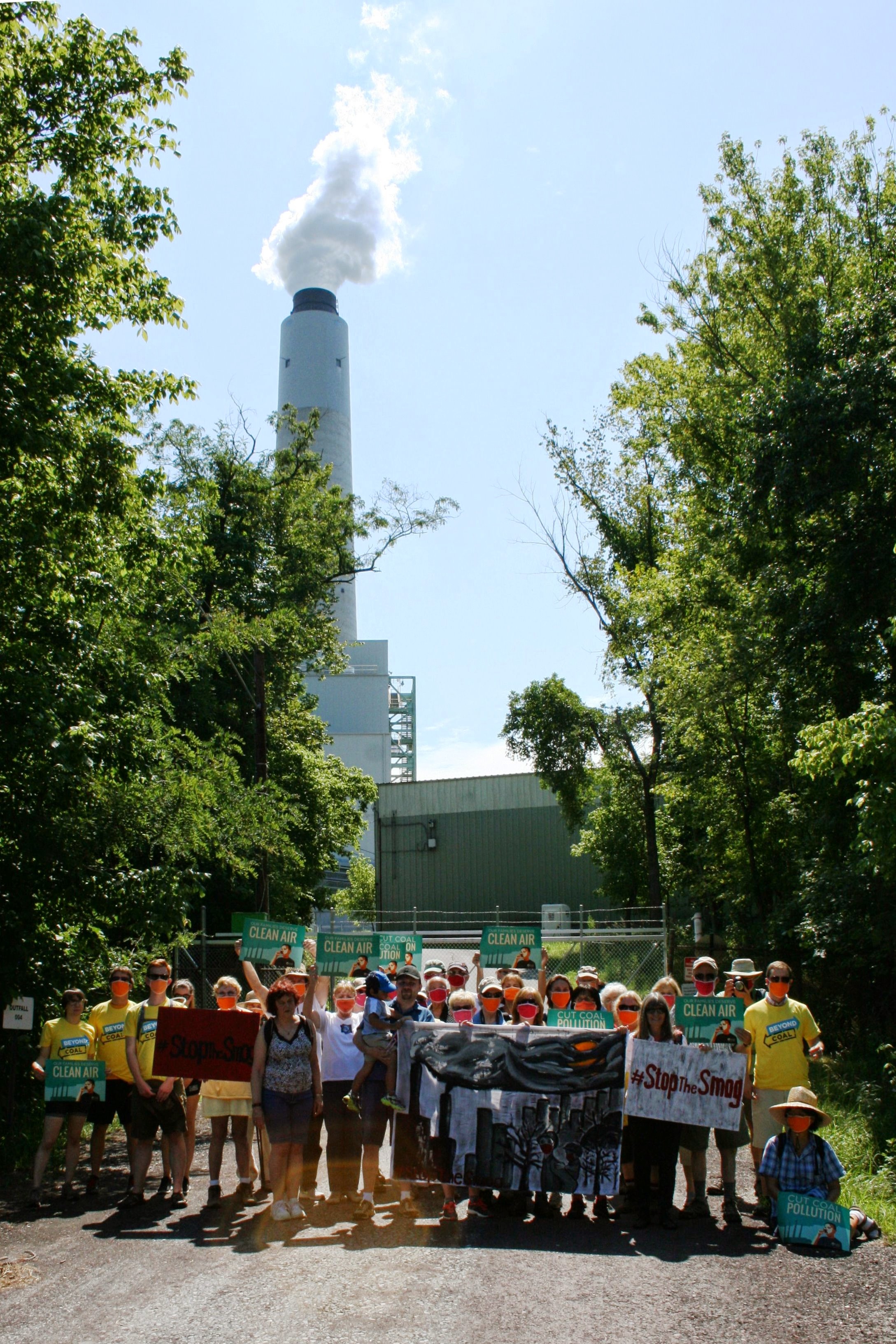 Kayakers holding a sign that says "retire" in front of the Crane coal plant.
