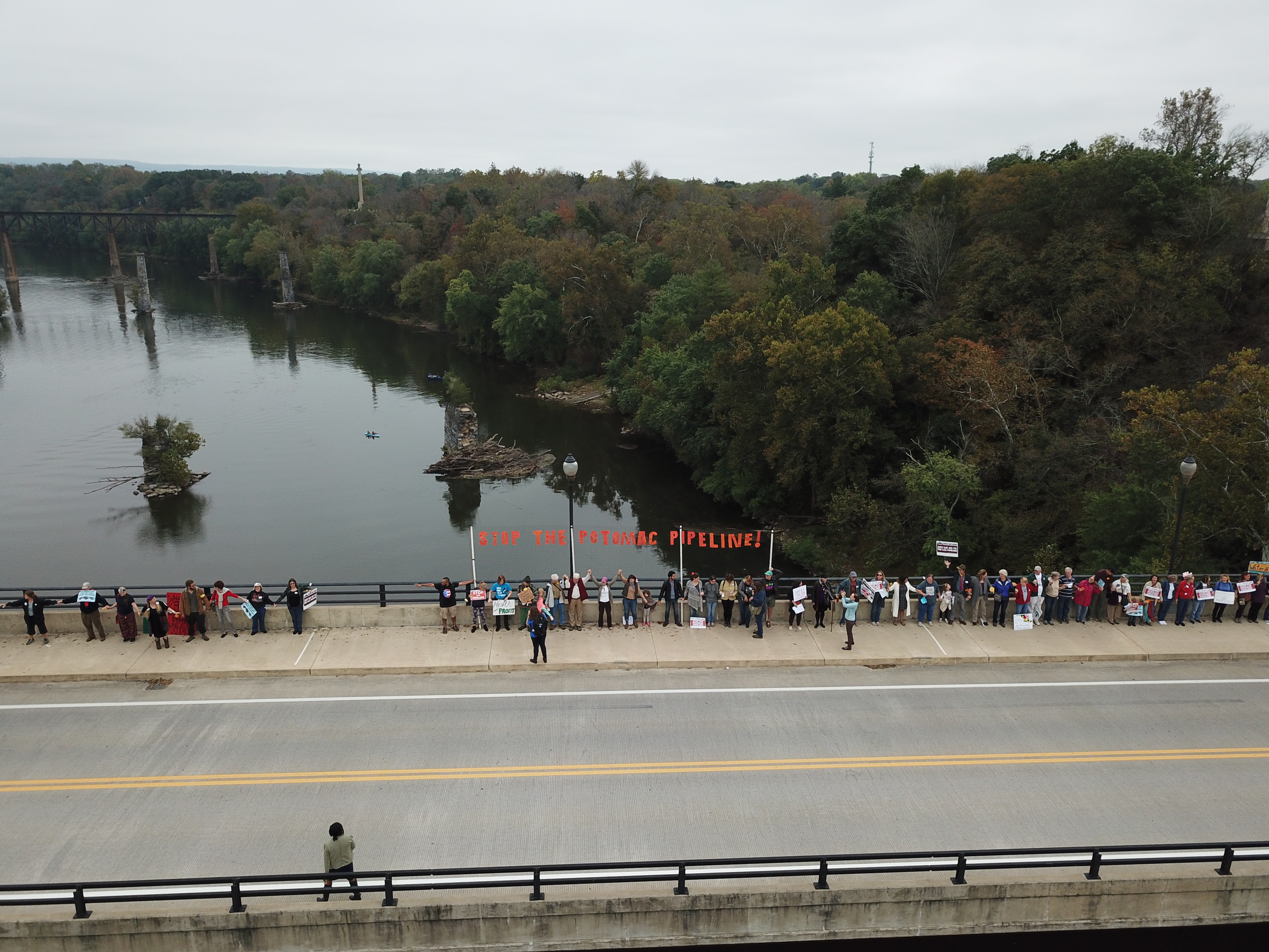 People gathered on bridge with sign "Stop Potomac Pipeline"