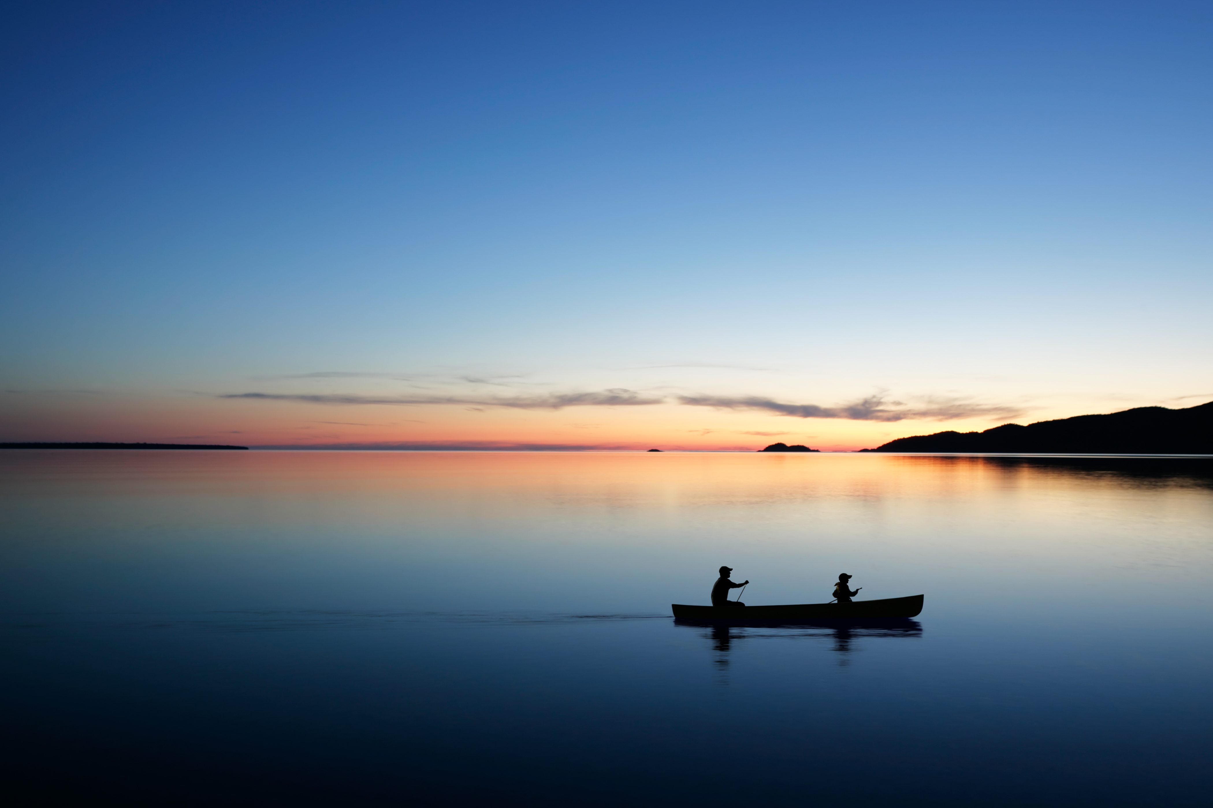 photo of canoeing on a lake after sunset