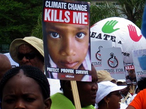 Climate Changes Kills Me with child's face sign at a protest