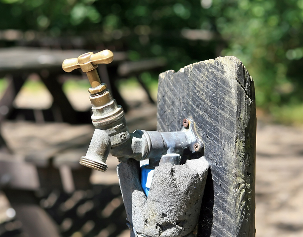 Dry brass water faucet in sun outdoors