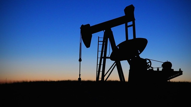 Oil pump jack in silhouette at dusk