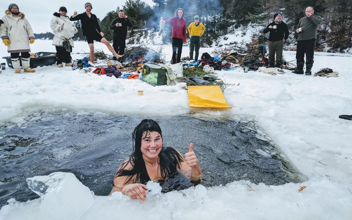 Woman in a swimming hole in winter in ice and snow