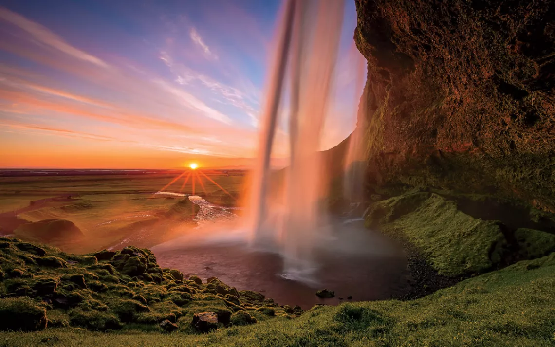 A sight to keep you up at night, delightfully: The setting midnight sun and Iceland’s Seljalandsfoss waterfall.