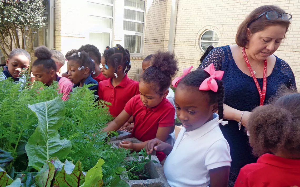 A teacher and students in the garden at L.S. Rugg Elementary School in Alexandria, Louisiana.