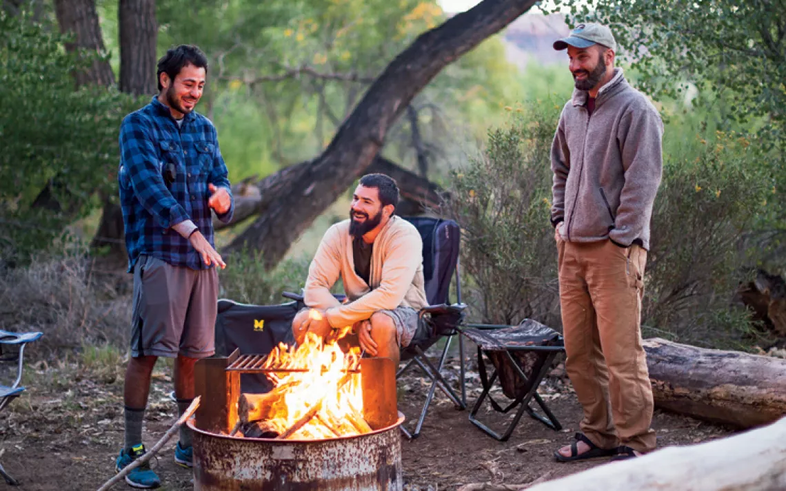 Veterans Kajetan Bauer, Brandon Lay, and Armando Medina sit around a campfire near Cedar Mesa, Utah.