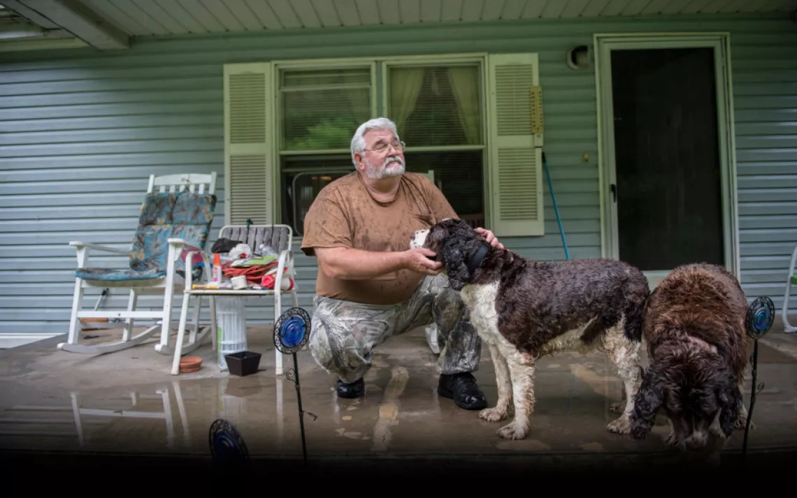 Charles Bella on the porch of his home in Blair, West Virginia. Dust, noise, and explosions from a nearby mountaintop-removal mine have caused Blair's population to dwindle from 700 people in the 1990s to fewer than 50 today, according to the Blair Mounta