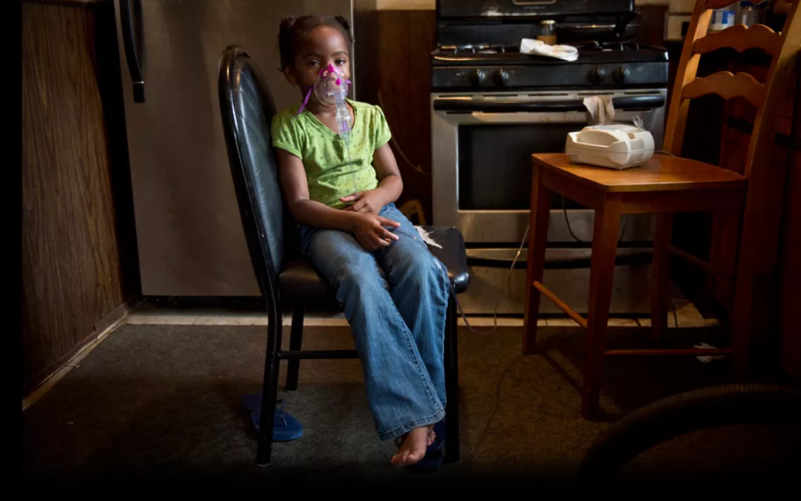La'Miyah Hildreth, 5, wears a nebulizer in the kitchen of her grandmother Siobhan Washington. | Ami Vitale/Panos Pictures