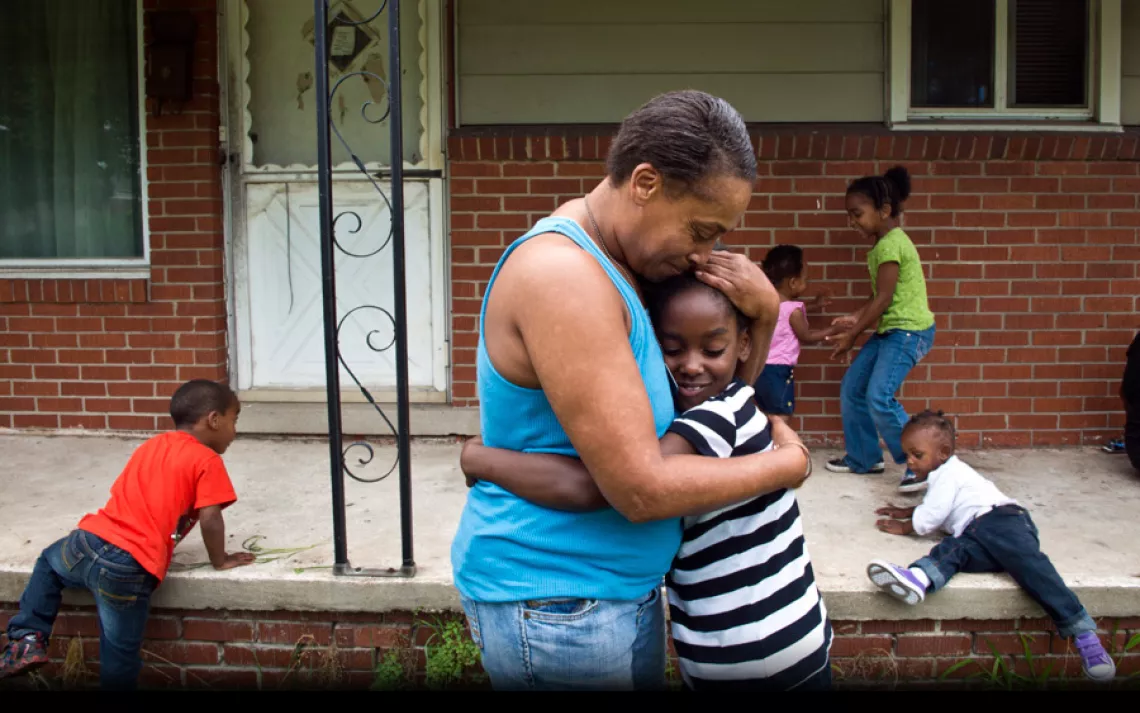 In front of her River Rouge home, Siobhan Washington hugs granddaughter Marianna Hildreth while some of her other grandchildren play. "I don't understand why more people aren't concerned about it," she said of her hometown. "People are dying off, slowly b