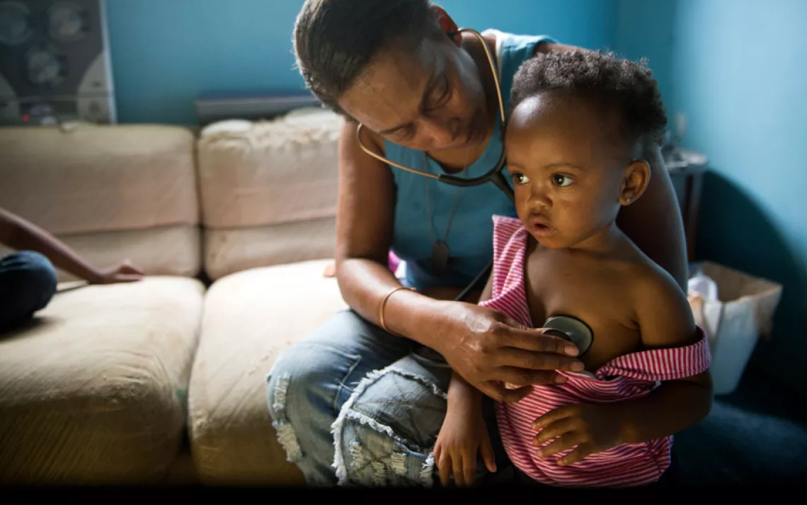 Siobhan Washington checks the breathing of granddaughter Mariyah McGhee, 1, in her River Rouge, Michigan, home. | Ami Vitale/Panos Pictures