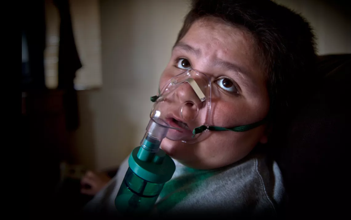 Lane Miller demonstrates his nebulizer in his home on the Moapa Band of Paiutes Reservation in Nevada. "At least once a month he has to use a nebulizer to open up his lungs," his mother, Kami, said. "If I neglect it, he has to go on steroids or it can tur