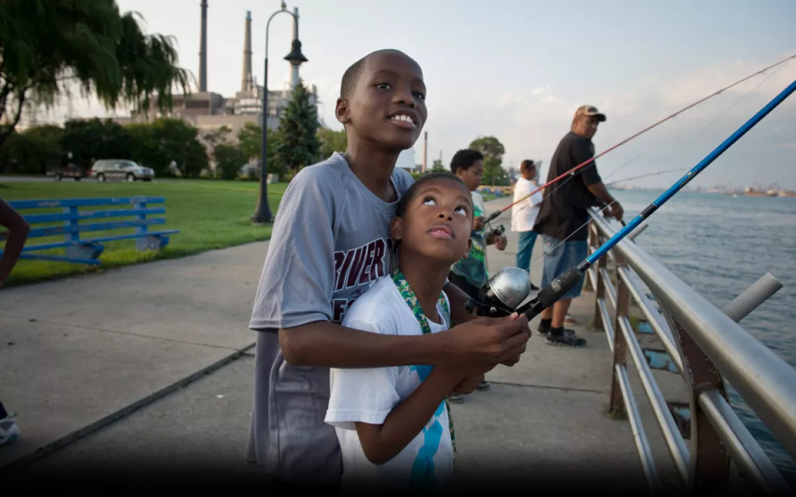 Jayvon Riley, 11, fishes in the Detroit River with his friend James Beverly, 7. Health advocates routinely pass out flyers along the river warning that certain kinds of fish shouldn't be eaten because they might be contaminated. | Ami Vitale/Panos Picture