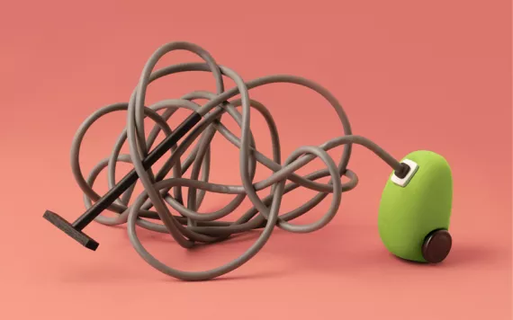 A little green vacuum has long cord tied up in knots against a pink-orange background.