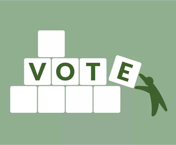 "VOTE" spelled out in blocks, being built by a small green figure.