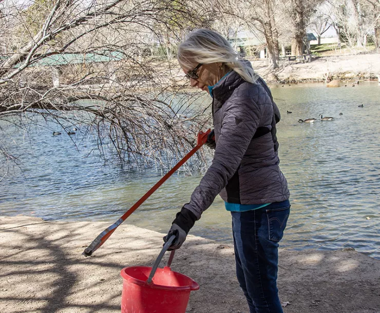 FLOYD-LAMB-CLEANUP.18-Southern Nevada Group-Sierra Club member Diana Baker picking up debris by one of the four ponds at Floyd Lamb Park at Tule Springs.