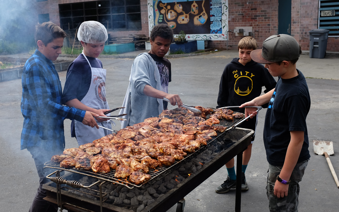 Middle schoolers grill meat for the Growing Leaders program in Berkeley, California.