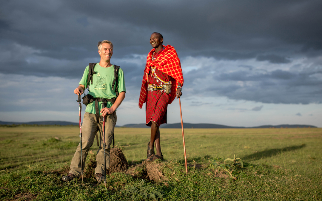 Author and travel writer Stuart Butler and his Maasai guide and companion Josphat Mako survey the landscape in the Mara North Conservancy adjacent to Kenya&#039;s world famous Maasai Mara National Reserve.