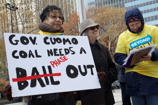 A Beyond Coal demonstrator holds up a sign calling for a coal phase-out.  