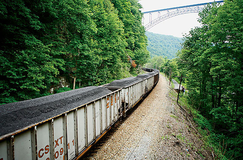 A coal train runs under the iconic bridge across the New River Gorge.