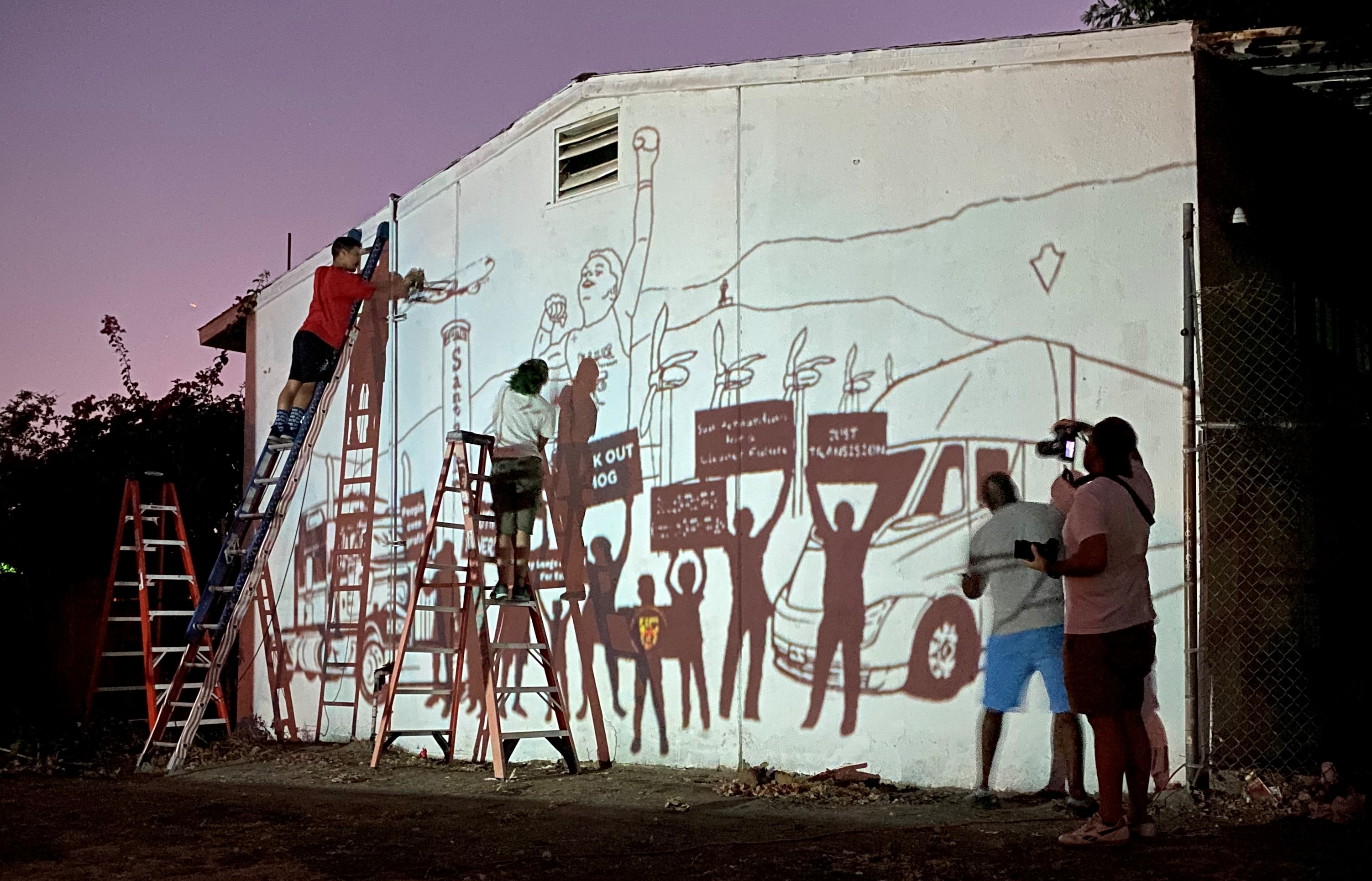 Artists work on the mural