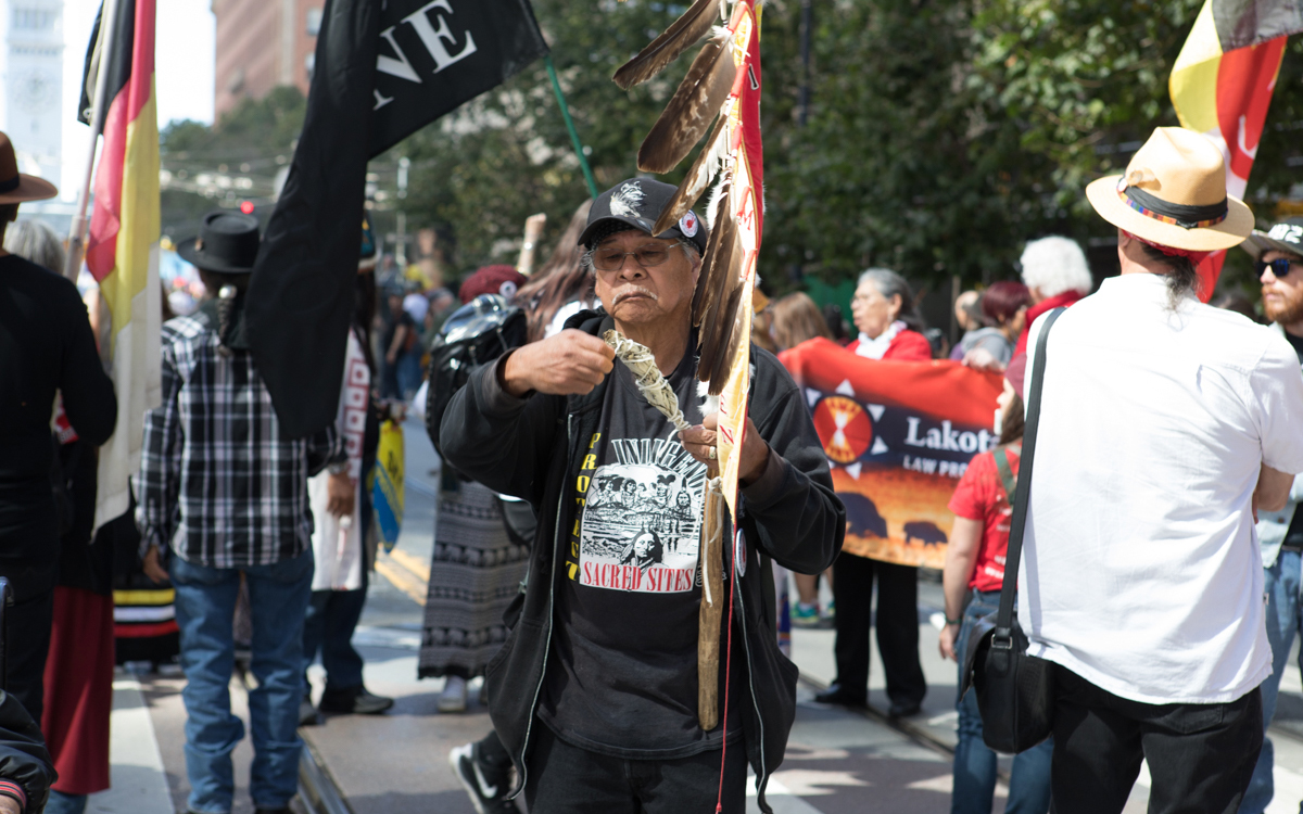 A marcher with the Native American contingent burns sage. 