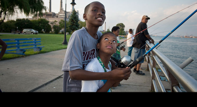Alisha Winters's son Jayvon Riley, 11, fishes in the Detroit River with his friend James Beverly, 7. Health advocates routinely pass out flyers along the river warning that certain kinds of fish shouldn't be eaten because they might be contaminated. | Ami