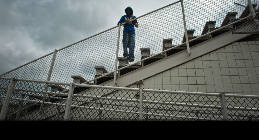 Robert Connor looks down from the football stadium bleachers at River Rouge High School. | Ami Vitale/Panos Pictures