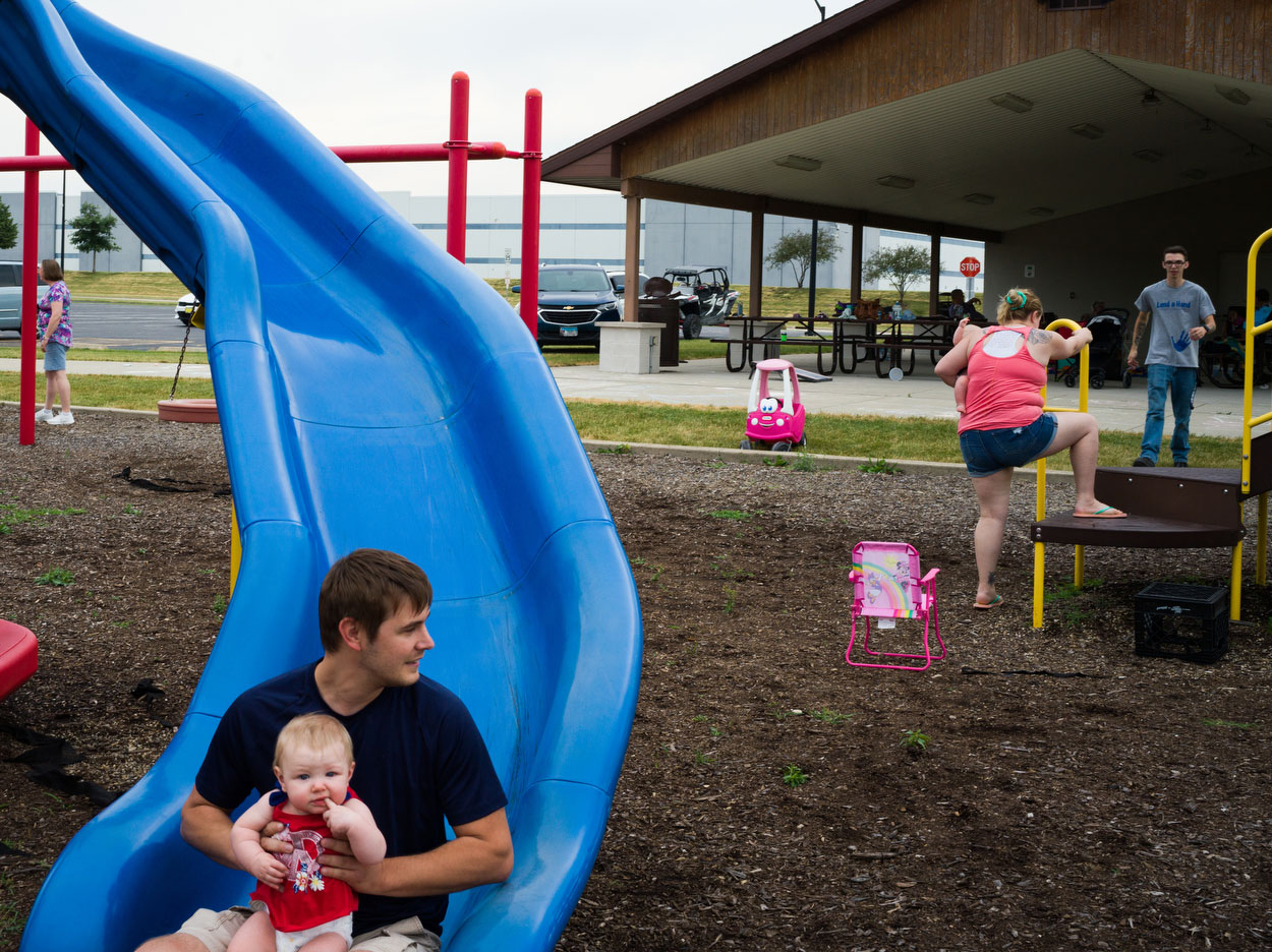 Father and child on playground slide in Joliet.