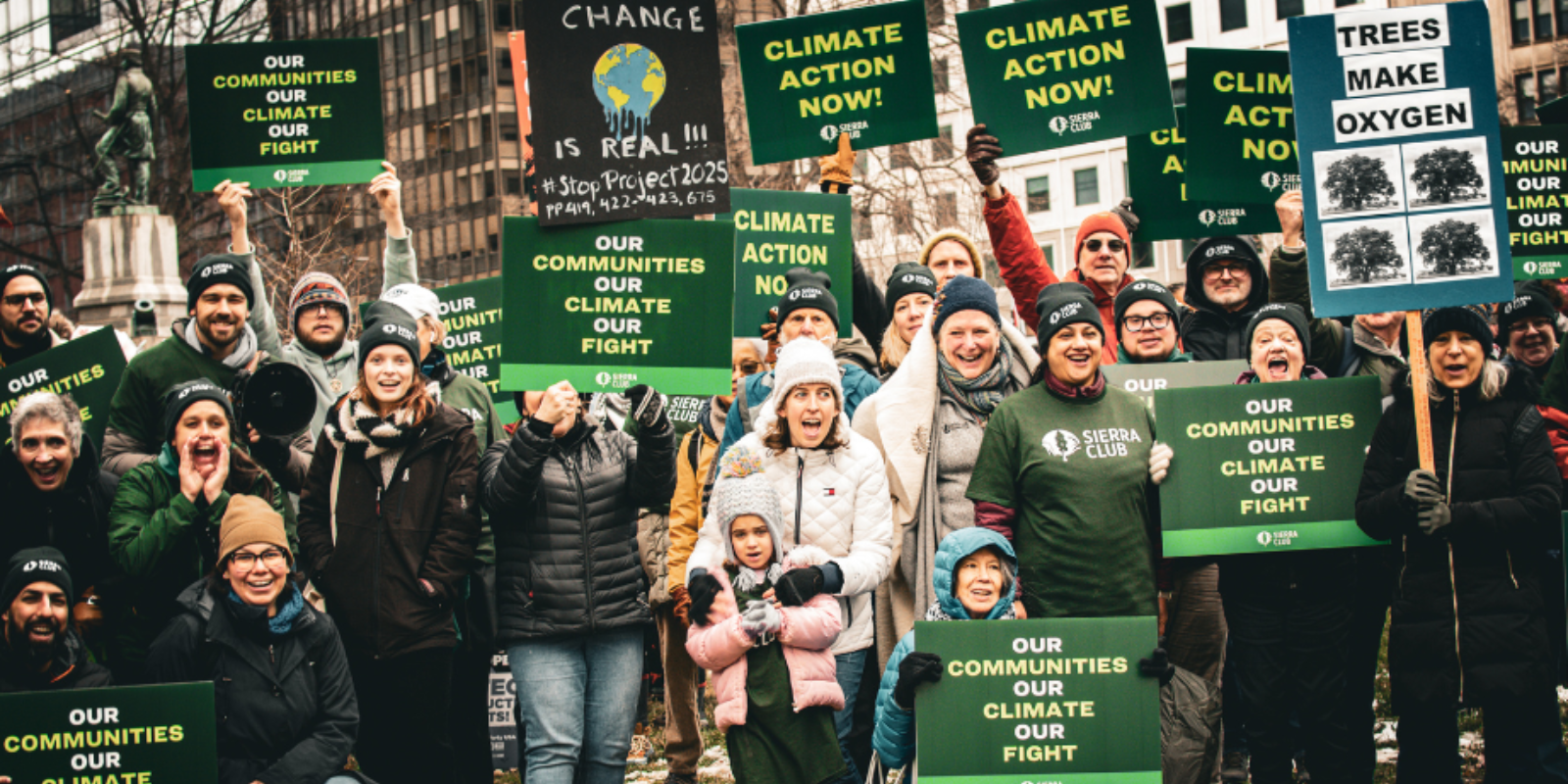 protesters holdin our communities, our climate, our fight signs
