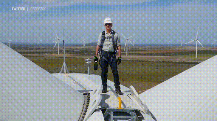 Amazon CEO Jeff Bezos smashes champagne bottle on top of windmill - Imgur.gif