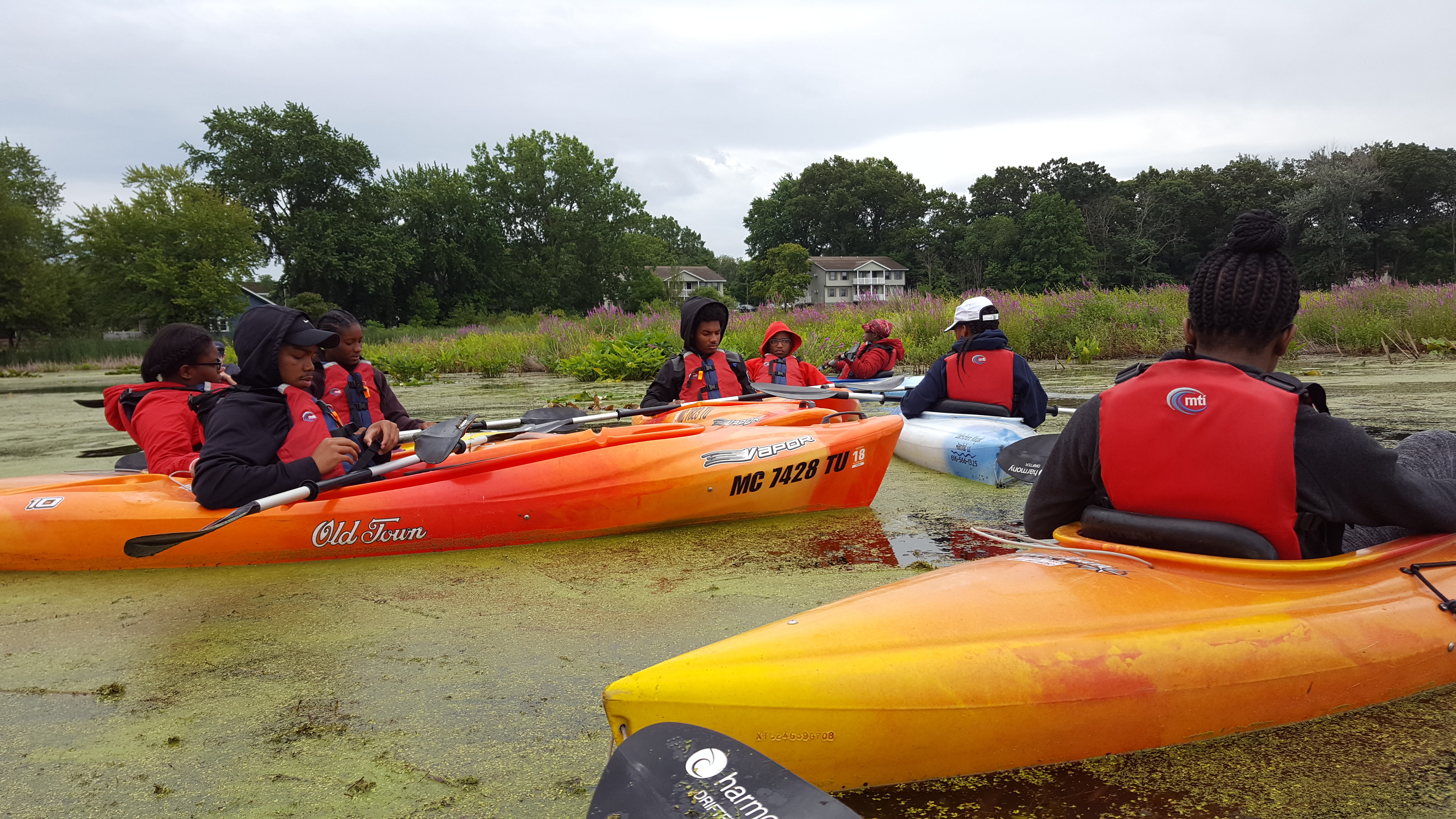 Detroit ICO participants gather together on the water in their kayaks.