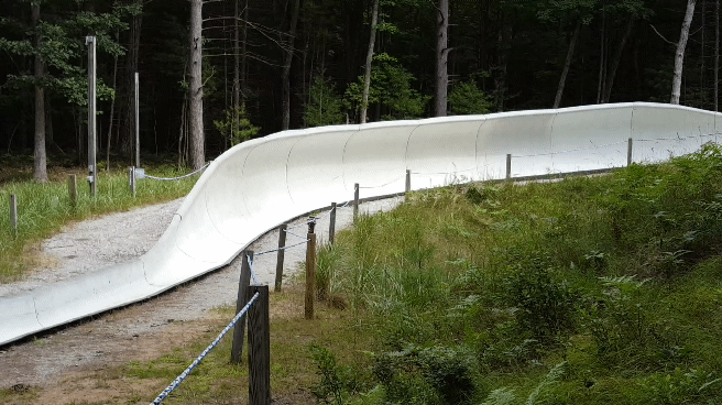 David Taylor rushes down the luge track at a sports complex.