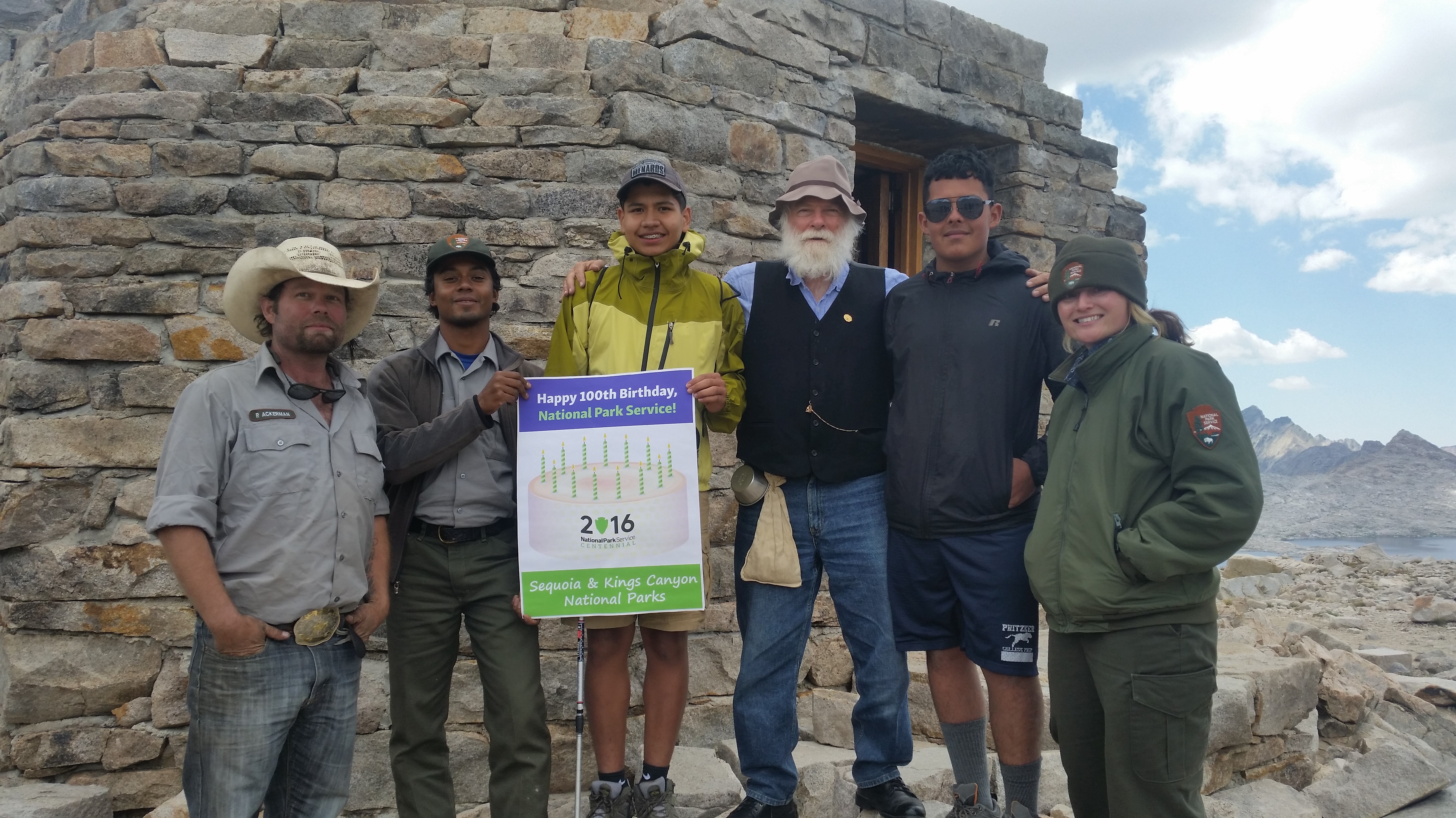 Leo Hernandez stands with another ICO participant and with NPS staff in front of John Muir's Hut.