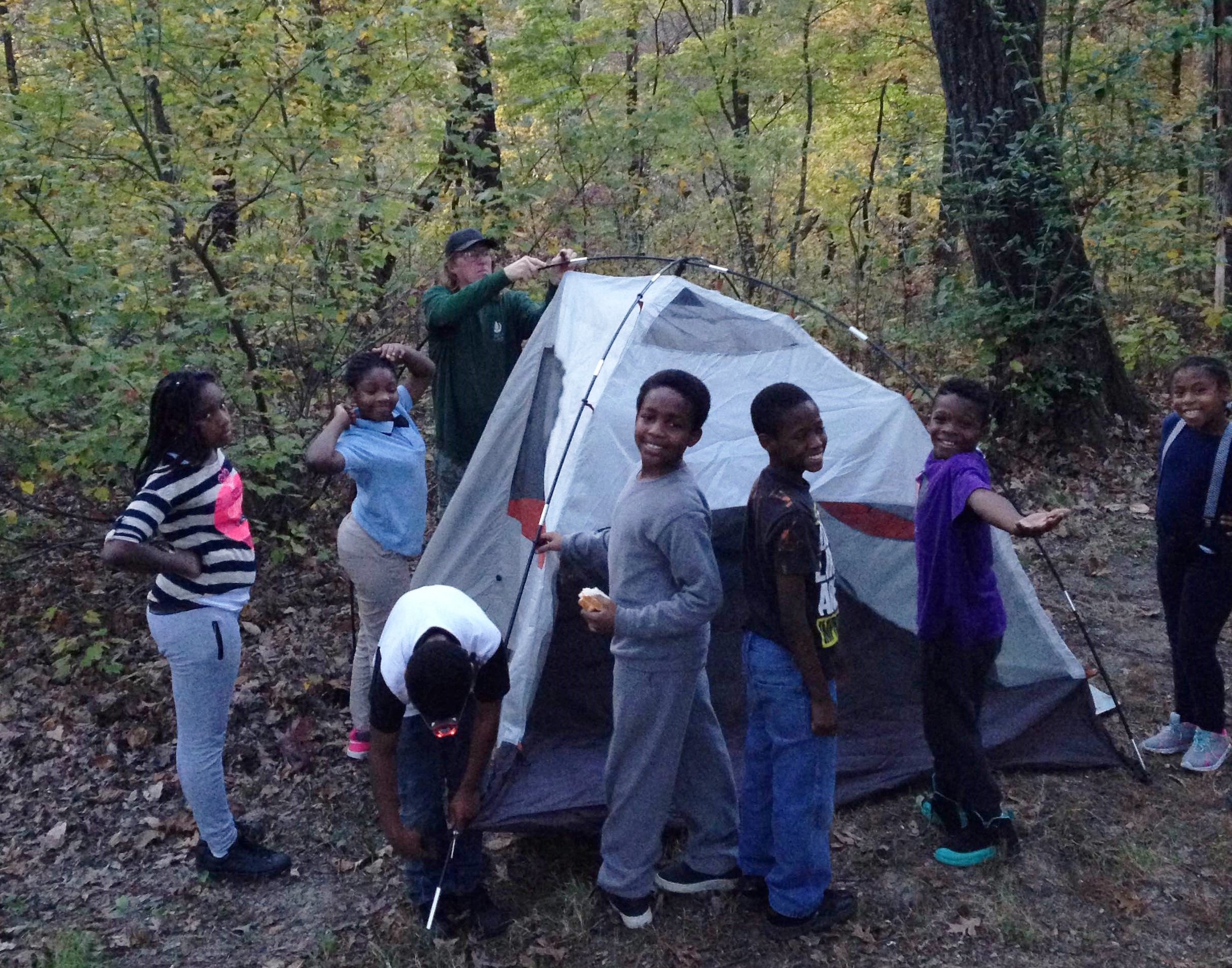 Young St. Louis ICO participants help set up a tent at their campsite.