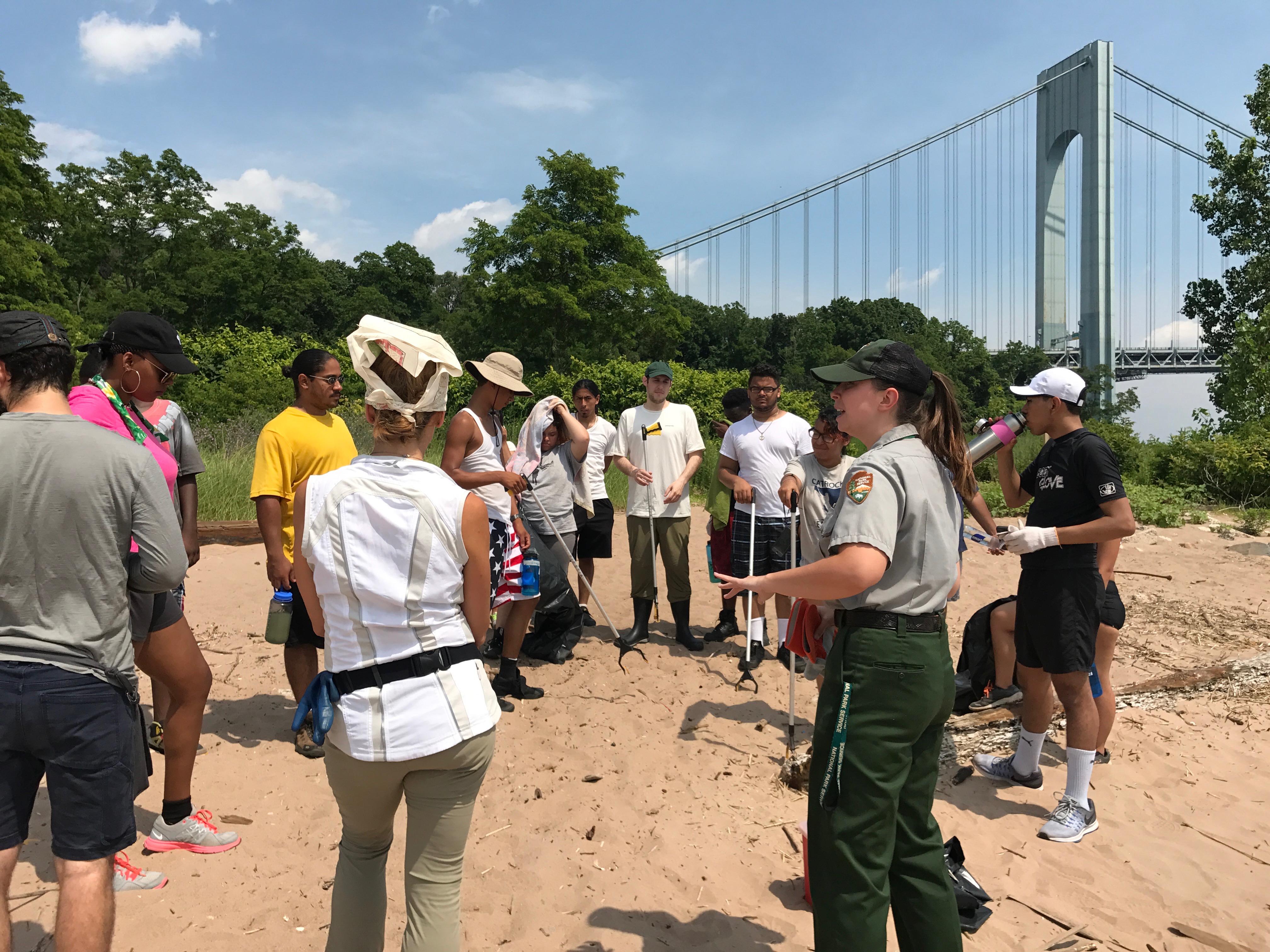 NYC ICO participants engage in a beach cleanup with a member of the park staff. 