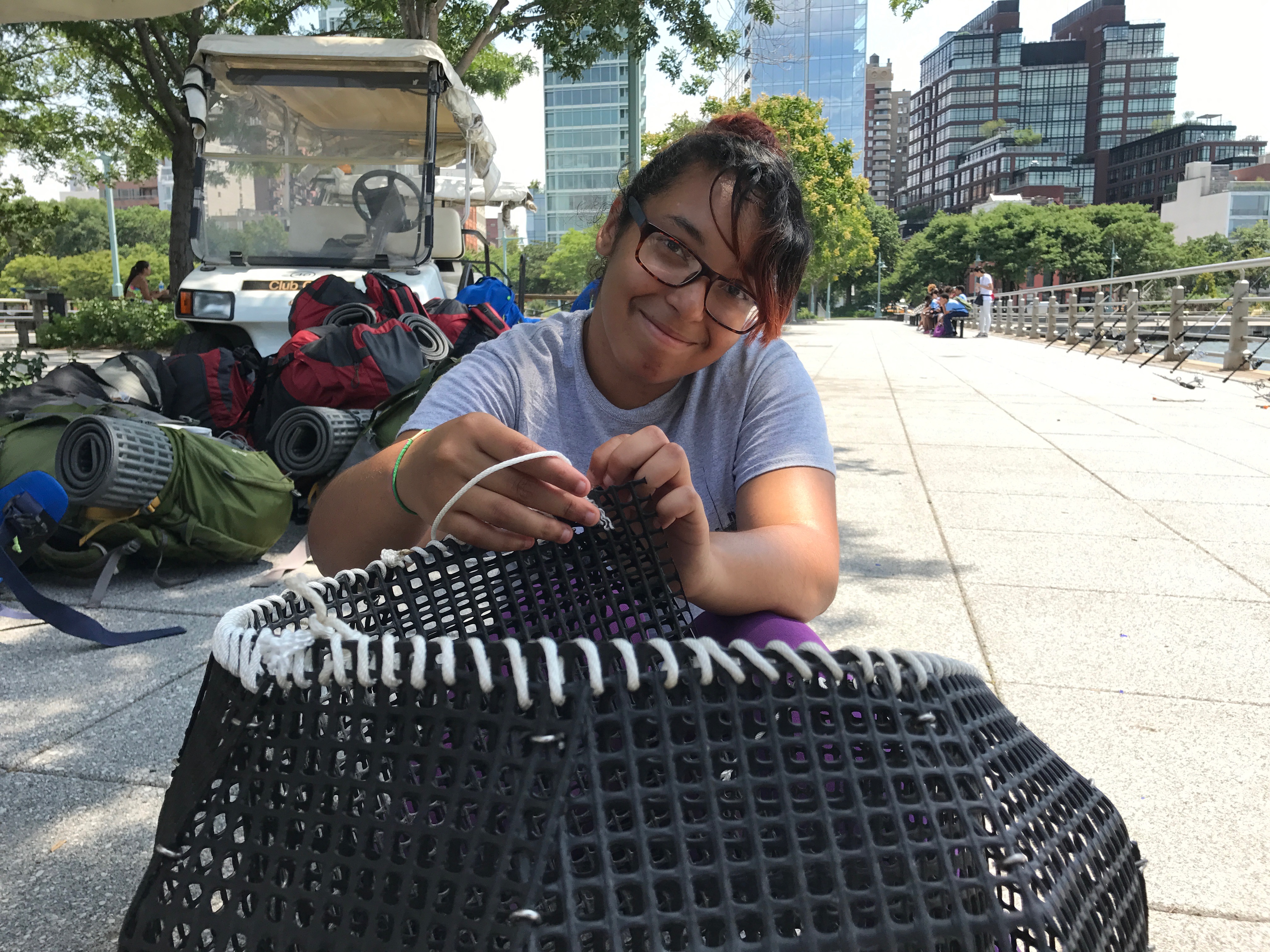NYC ICO participant helps Hudson River Park staff put together a net as part of their oyster conservation project.