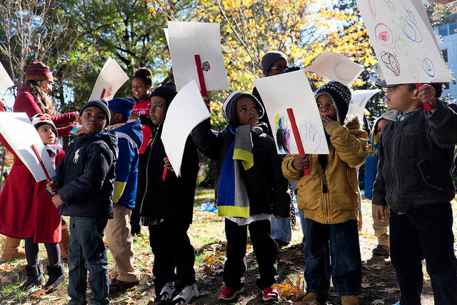 Kids hold up signs at clean-energy rally