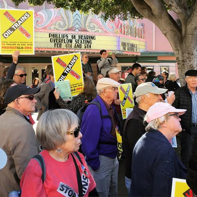 Rally participants listen to a speaker, across the street from overflow seating in the Fremont Theater