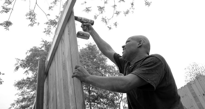 Stacey Ryan building a fence around his property