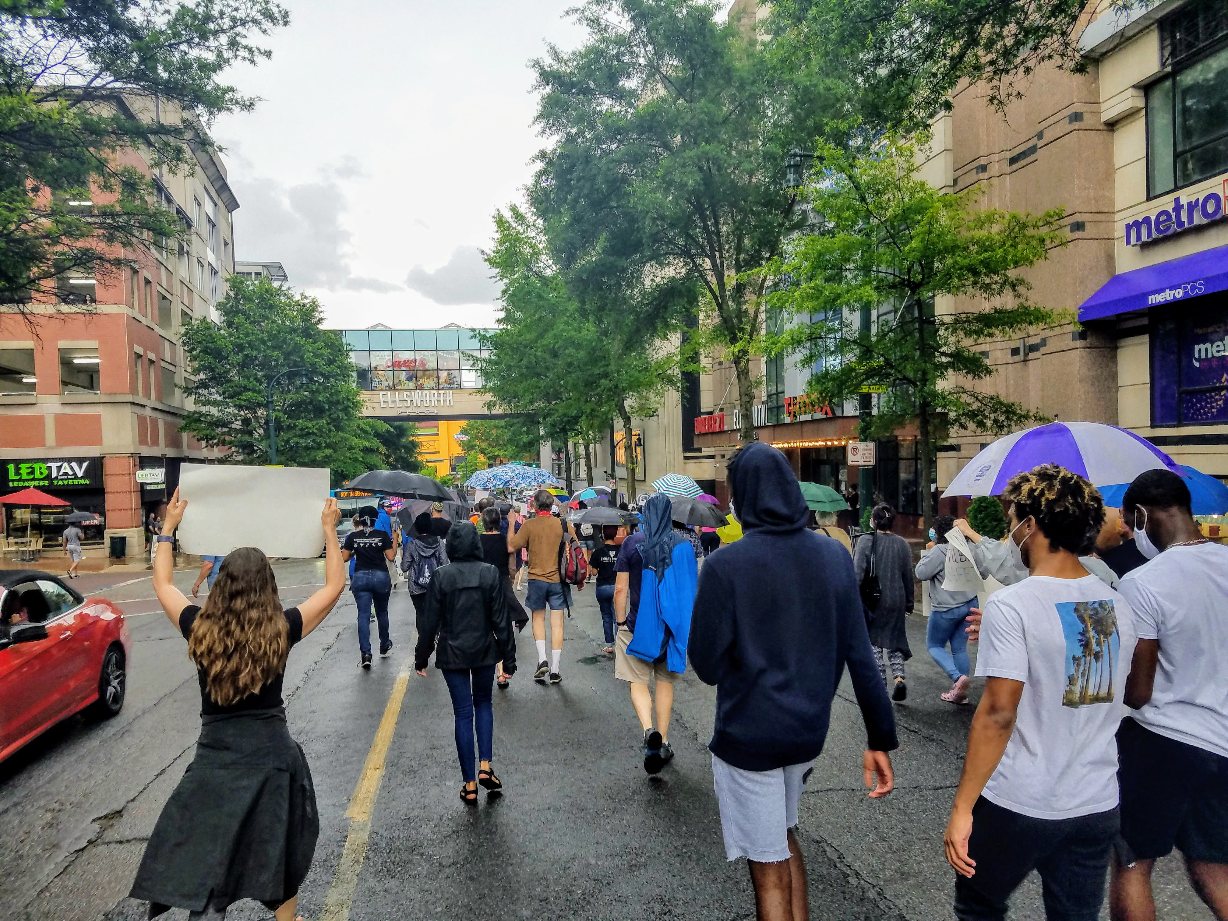 People marching outside with signs in the rain for Juneteenth.