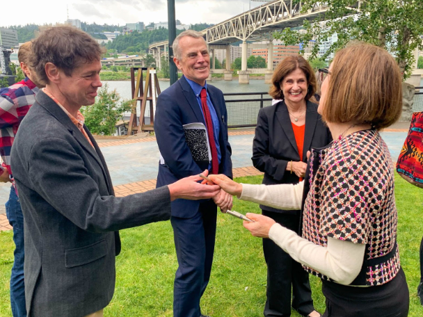 Oregon Sierra Club Conservation Director Rhett Lawrence shakes hands with Gov. Kate Brown.