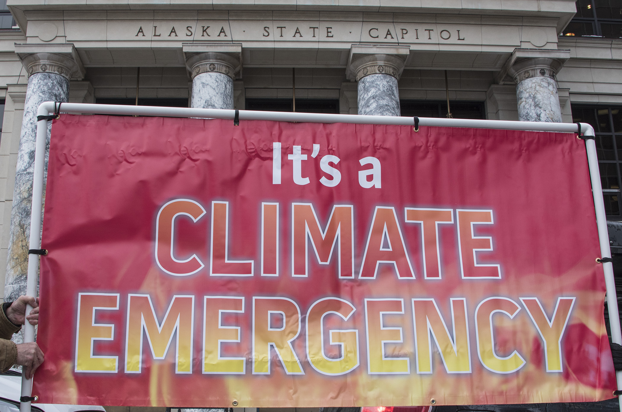 Climate emergency banner held up in front of a building