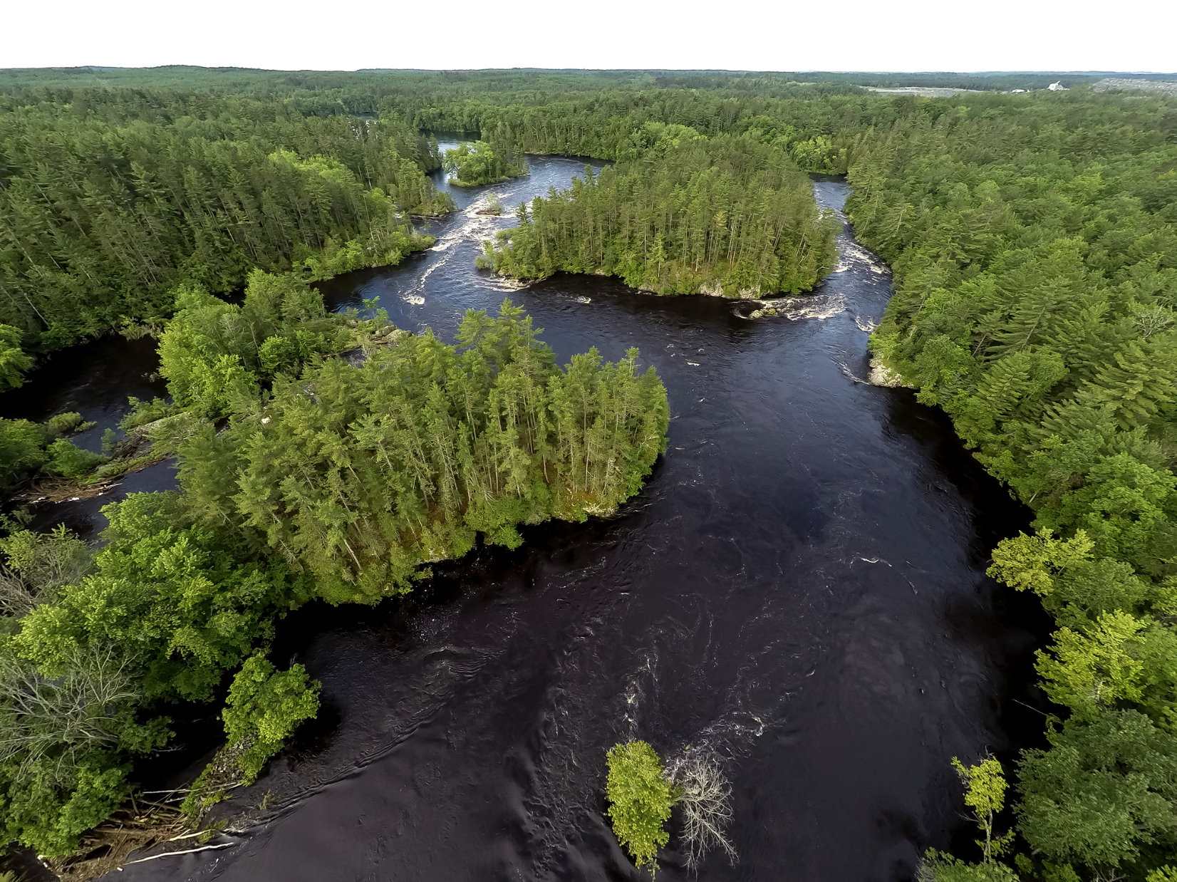 The waters of the Menominee River flow through forested areas
