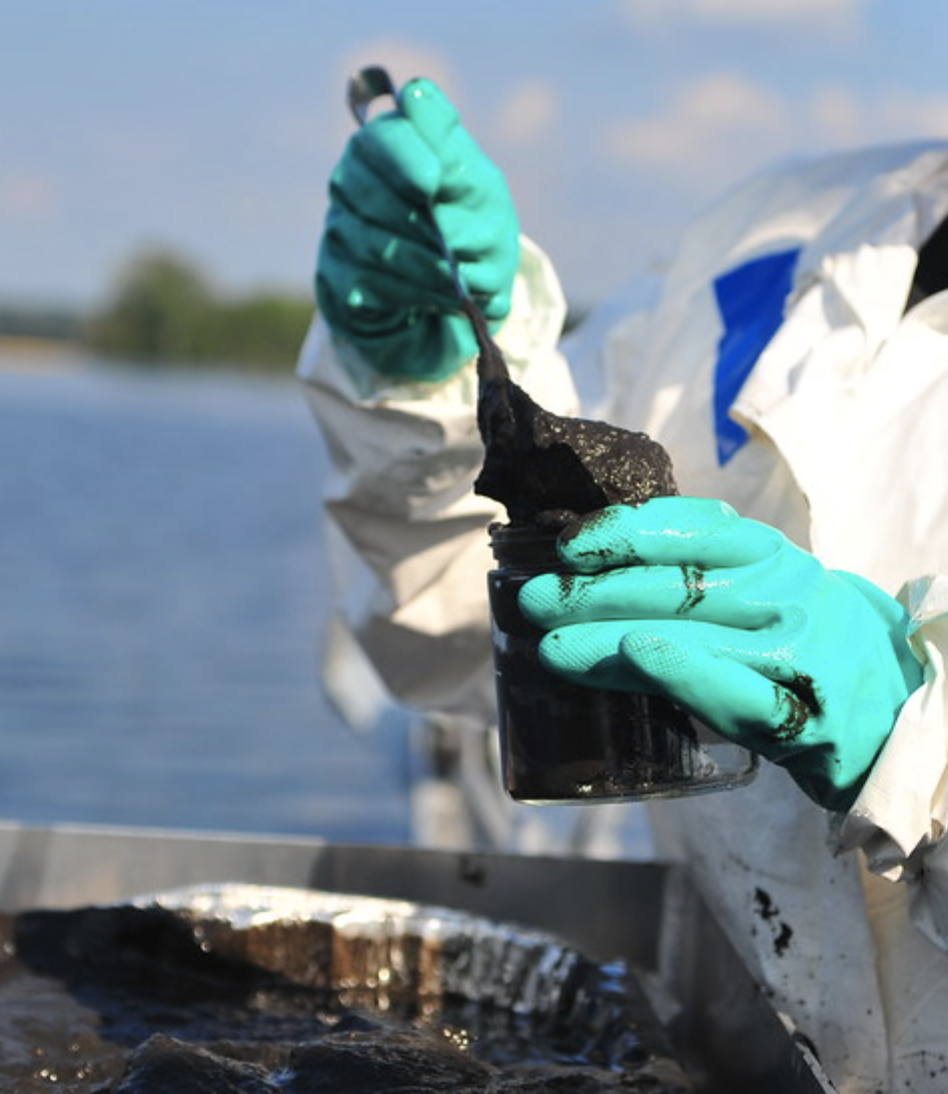 EPA worker holding a jar of tar sands