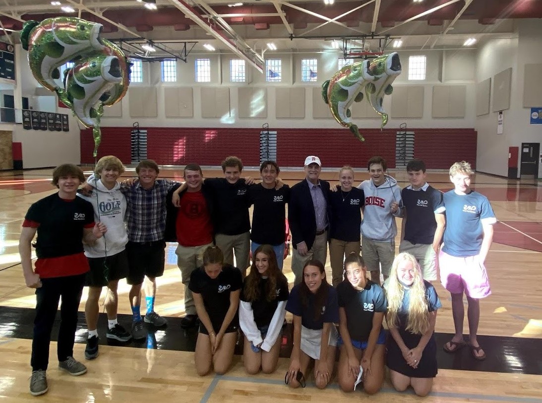 Group of high school students posing with Rep. Simpson, holding salmon balloons