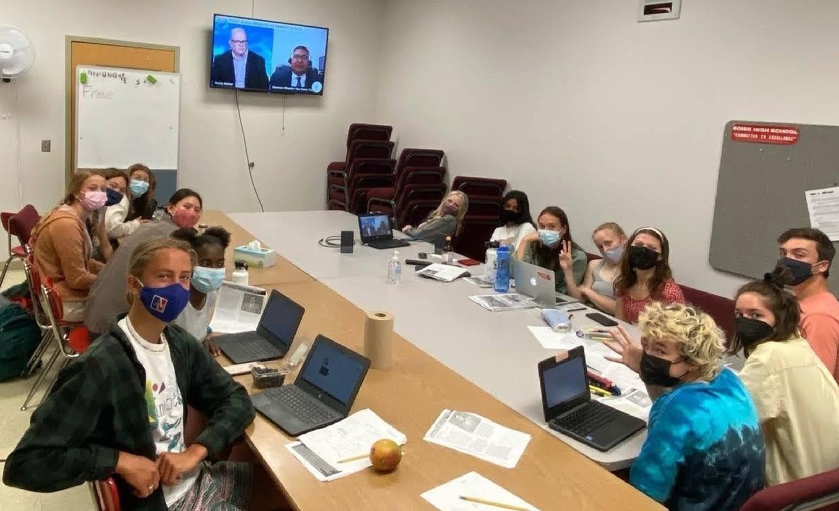 High school students sitting around a table watching the Andrus Conference on a screen on the wall